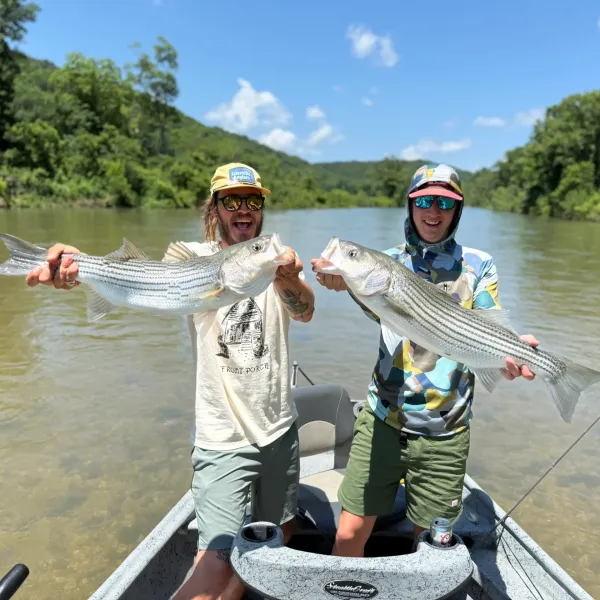 two men holding large fish